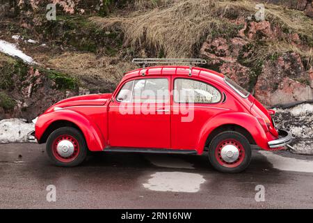 Vyborg, Russland - 15. April 2023: Der alte rote Volkswagen Kafer steht an einem Straßenrand, Seitenansicht Stockfoto