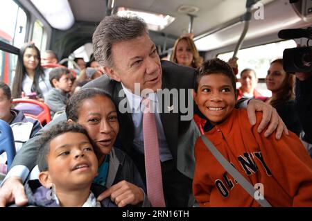 (141201) -- BOGOTA, 1. Dezember 2014 -- Bild von zeigt den kolumbianischen Präsidenten Juan Manuel Santos (C), der am 1. Dezember 2014 in Bogota, der Hauptstadt Kolumbiens, mit Passagieren des städtischen Personenverkehrs Transmilenio posiert. Der Chefunterhändler der kolumbianischen Regierung Humberto de la Calle sagte am Sonntagabend, dass eine Delegation der kolumbianischen Regierung nach Havanna reisen werde, um ein zweitägiges Treffen mit der Delegation der bewaffneten Revolutionsstreitkräfte Kolumbiens (FARC) zu führen, so die lokale Presse. Cesar Carrion/) (da) KOLUMBIEN-BOGOTA-POLITICS-SANTOS-FARC-NEGOTIATION COLOMBIA SxPRESIDE Stockfoto