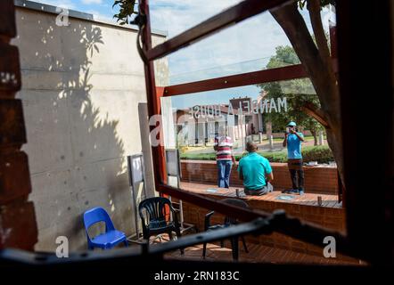 (141204) -- JOHANNESBURG, 4. Dezember 2014 -- A vistor (C) posiert für ein Foto vor dem Nelson Mandela National Museum in Soweto, südwestlich von Johannesburg, Südafrika, am 4. Dezember 2014. Das Nelson Mandela National Museum, allgemein als Mandela House bezeichnet, befindet sich in Soweto, südwestlich von Johannesburg, Südafrika, wo Nelson Mandela von 1946 bis 1962 lebte. Als sich der 1. Jahrestag von Nelson Mandelas Tod am 5. Dezember nähert, kommen immer mehr Besucher in das Museum, um dem Präsidenten Südafrikas zu gedenken. ) SÜDAFRIKA-SOWETO-MANDELA-HAUS-1. A Stockfoto