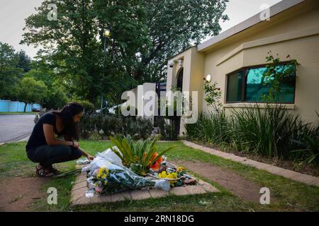 (141205) -- JOHANNESBURG, 5. Dezember 2014 -- Eine Frau legt am 5. Dezember 2014 vor Nelson Mandelas Residenz in Johannesburg, Südafrika, einen Blumenstrauß. Die Menschen gingen in die Residenz des verstorbenen südafrikanischen Präsidenten Nelson Mandela in Houghton, wo er am 5. Dezember 2013 in Johannesburg, Südafrika, verstarb, um ihr Beileid zum Ausdruck zu bringen und an den 1. Jahrestag des Todes Nelson Mandelas zu gedenken. SÜDAFRIKA-JOHANNESBURG-MANDELA-JAHRESTAG-TODESGEDENKEN ZhaixJianlan PUBLICATIONxNOTxINxCHN Johannesburg DEZ 5 2014 eine Frau legt ein Blumenstrauß vor Nelson Mandela S Stockfoto