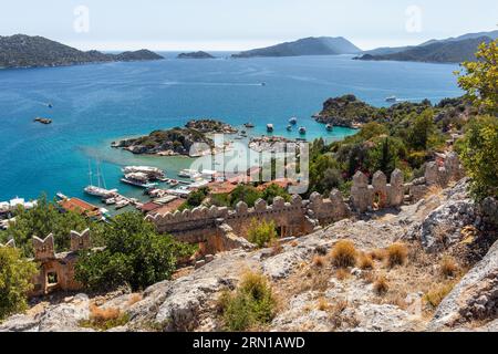 Panoramaaussicht von der Burg Simena, einschließlich der zinnenbewehrten Mauern der Burg, des natürlichen Hafens, der Dächer des Dorfes und des Mittelmeers, Simena, Türkei Stockfoto