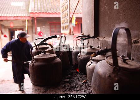 Ein Arbeiter mischt Kohle mit Ton, um Teekanne in einem alten Teehaus in Linhuan Town, Suixi County der Stadt Huaibei, ostchinesische Provinz Anhui, 11. Dezember 2014 zu kochen. Die Stadt Linhuan, im Südwesten des Komitats Suixi der Stadt Huaibei in der ostchinesischen Provinz Anhui gelegen, hat eine lange Geschichte, die auf mehr als viertausend Jahre zurückgeht. Die Einheimischen von Linhuan haben die Tradition des Teetrinkens seit der Ming-Dynastie beibehalten, die ihren Druck auf das Leben der Menschen hier durch den alten quadratischen Tisch, die raue Sandschale und die rostige Kupfer-Teekanne hinterlässt. Kunden kommen normalerweise um zehn Uhr im Teehaus Stockfoto