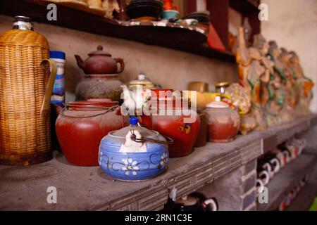 Alte Teekannen sind in einem alten Teehaus in Linhuan Town, Suixi County der Stadt Huaibei, ostchinesische Provinz Anhui, 11. Dezember 2014, zu sehen. Die Stadt Linhuan, im Südwesten des Komitats Suixi der Stadt Huaibei in der ostchinesischen Provinz Anhui gelegen, hat eine lange Geschichte, die auf mehr als viertausend Jahre zurückgeht. Die Einheimischen von Linhuan haben die Tradition des Teetrinkens seit der Ming-Dynastie beibehalten, die ihren Druck auf das Leben der Menschen hier durch den alten quadratischen Tisch, die raue Sandschale und die rostige Kupfer-Teekanne hinterlässt. Die Gäste erscheinen normalerweise um zehn Uhr morgens im Teehaus, wo sie können Stockfoto