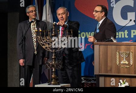 JERUSALEM, der israelische Premierminister Benjamin Netanjahu (C) zündet Kerzen an einem Hannukiya an, um den zweiten Tag von Hanukkah während des jährlichen Empfangs des Regierungs-Presseamtes (GPO) im Israel Museum in Jerusalem am 17. Dezember 2014 zu feiern. Hanukka trat am zweiten Tag am Mittwoch ein. Hanukkah, auch bekannt als das Festival der Lichter und das fest der Widmung, ist ein achttägiger jüdischer Feiertag zur Erinnerung an die Wiederweihung des Heiligen Tempels (der zweite Tempel) in Jerusalem zur Zeit der Makkabäer-Revolte gegen das Seleukidenreich im 2. Jahrhundert v. Chr. wird Hanukkah acht Nächte und Tage lang beobachtet Stockfoto