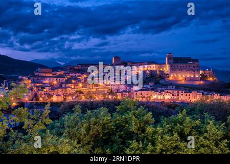 Die Häuser der kleinen Stadt Altomonte, auf einem Hügel gelegen, beleuchtet bei Nacht. Stockfoto