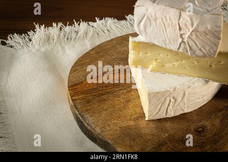 Camembert und Brie-Käse auf hölzernem Hintergrund mit Nüssen, Honig und Früchten. Milchprodukte. Stockfoto
