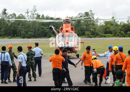 Absturz von AirAsia-Flug QZ8501 - Opfer werden geborgen Menschen versammeln sich um einen Hubschrauber, der Leichen von Opfern auf AirAsia-Flug QZ8501 auf dem Luftwaffenstützpunkt Iskandar in Pangkalan Bun, Zentral-Kalimantan, Indonesien, Dezember 31, bringt. 2014. indonesische Rettungskräfte, die nach dem vermissten Flugzeug von AirAsia suchen, haben sechs Leichen entdeckt und drei aus Gewässern vor der Südküste der Insel Kalimantan geborgen, kurz nachdem sie schwimmende Trümmer beobachteten, die später bestätigt wurden, dass sie von dem unglückseligen Flugzeug stammen. ) INDONESIEN-PANGKALAN BUN-AIRASIA-OPFER VerixSanovri PUBLICATIONxNOTxINxCHN Absturz von AirAsia Flight Vict Stockfoto