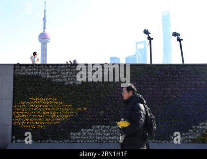 AKTUELLES ZEITGESCHEHEN 36 Tote bei Massenpanik in Shanghai (150101) -- SHANGHAI, 1. Januar 2015 -- Ein Mann geht mit einem Blumenstrauß in der Hand am Bund vorbei in Shanghai, Ostchina, 1. Januar 2015. Die Neujahrsfeiern in Shanghais Bund-Gebiet verliefen Mittwochabend, als eine Stampede 35 Tote und 42 Verletzte forderte. Ein Zeuge sagte, dass einige Coupons, die wie Dollarscheine aussahen, aus dem Fenster eines Gebäudes im dritten Stock in der Nähe des Bundes geworfen wurden und Menschen, die am Flussufer standen, begannen, nach diesen Coupons zu suchen. Die Stadt hat ein Arbeitsteam für Rettungseinsätze und Deal eingerichtet Stockfoto