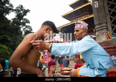 Kathmandu, Nepal. August 2023 31. Ein nepalesischer Devotee erhält während des Janai Purnima Festivals einen Janai oder heiligen Thread vom Priester. Janai Purnima, auch bekannt als das Sacred Thread Festival oder Rakshya Bandhan Festival, führen Hindus, insbesondere die Brahmans und Chettris, ihren jährlichen Wechsel von Janai auf, heilige Fäden, die über die Brust getragen oder um das Handgelenk gebunden und von Mantras gereinigt werden. Das Gewinde ist ein Symbol für Schutz. Quelle: SOPA Images Limited/Alamy Live News Stockfoto