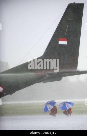 AKTUELLES ZEITGESCHEHEN Absturz von AirAsia-Flug QZ8501 - schlechtes Wetter erschwert Suche nach Flugschreiber (150104) -- PANGKALAN BUN, 4. Januar 2015 -- indonesische Luftwaffenpiloten halten Regenschirme, um Schutz vor starkem Regen zu erhalten, während ihr Flugzeug am 4. Januar 2015 in Pangkalan Bun, Indonesien, abgesagt wird. Das Such- und Rettungsteam muss noch die schwarzen Boxen des abgestürzten AirAsia-Fluges QZ8501 finden, da noch immer schlechtes Wetter auf der Absturzstelle herrscht, sagte ein indonesischer Beamter hier am Samstag. ) INDONESIEN-PANGKALAN BUN-AIRASIA-SCHWERER REGEN AGUNGXKUNCAHYAXB. PUBLICATIONxNOTxINxCHN News aktuelle Ereignisse C Stockfoto