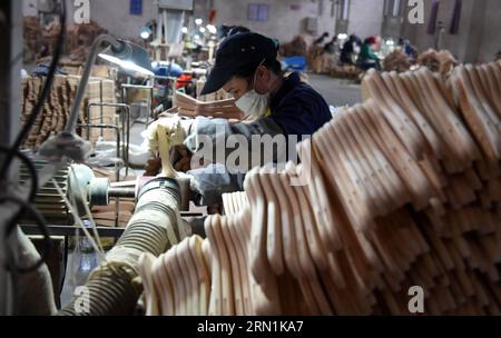 WIRTSCHAFT China - Bügel-Produktion in Lipu (150107) -- LIPU (GUANGXI), 6. Januar 2015 -- Arbeiter verarbeiten Kleiderbügel in einer Fabrik im Kreis Lipu, südwestchinesische autonome Region Guangxi Zhuang, 6. Januar 2015. Mit 126 Fabriken, die Kleiderbügel herstellen, erreichte die jährliche Produktion des Handels in Lipu 6,5 Milliarden RMB Yuan (etwa 1,06 Milliarden US-Dollar). (wf) CHINA-GUANGXI-CLOTHES HANGER-INDUSTRY(CN) LuxBo an PUBLICATIONxNOTxINxCHN Economy China Bügelproduktion in Lipu Lipu Guangxi 6. Januar 2015 Arbeiter verarbeiten Kleiderbügel IN einer Fabrik in Lipu County Südwestchina S Guang Stockfoto