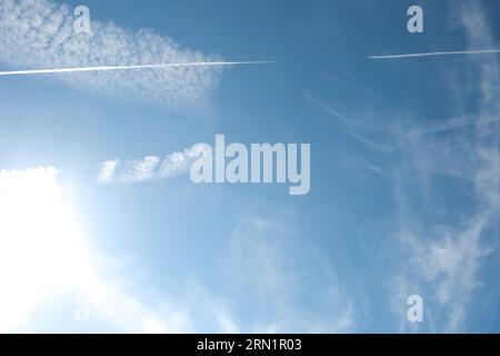 Cirrus-Wolken und lange Flugzeugroute. Aero-Flugzeug Contrail in blau bewölktem Himmel Hintergrund. Horizontale Linienführung vom fliegenden Schnellflugzeug in dista Stockfoto