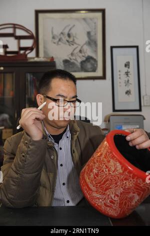 (150121) -- GU AN, 20. Januar 2015 -- der Handwerker Zhu Jiang entwirft in seiner Werkstatt in Gu an, Provinz Hebei, Nordchina, 20. Januar 2015 ein Stück geschnitzter Lackwaren. Das traditionelle chinesische handwerklich geschnitzte Lack, verziert mit exquisiten Gravuren und strahlend mit Glanz, wurde 2006 in der ersten Reihe von Schutzprojekten des nationalen immateriellen Kulturerbes aufgeführt. (wh) CHINA-HEBEI-GESCHNITZTE LACKWAREN (CN) LuxPeng PUBLICATIONxNOTxINxCHN GU bis 20. Januar 2015 der Handwerker Zhu Jiang entwirft in seiner Werkstatt in GU in Nordchina, Provinz Hebei, 20. Januar 2015 ein Stück geschnitzte Lackwaren Stockfoto