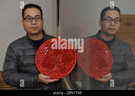 (150121) -- GU AN, 20. Januar 2015 -- der Handwerker Zhu Jiang hält in seiner Werkstatt in Gu an, nordchinesische Provinz Hebei, 20. Januar 2015, ein Stück geschnitzter Lackwaren. Das traditionelle chinesische handwerklich geschnitzte Lack, verziert mit exquisiten Gravuren und strahlend mit Glanz, wurde 2006 in der ersten Reihe von Schutzprojekten des nationalen immateriellen Kulturerbes aufgeführt. (wh) CHINA-HEBEI-GESCHNITZTE LACKWAREN (CN) LuxPeng PUBLICATIONxNOTxINxCHN GU zum 20. Januar 2015 der Handwerker Zhu Jiang hält in seiner Werkstatt in GU in der nordchinesischen Provinz Hebei am 20. Januar 2015 ein Stück geschnitzte Lackwaren Stockfoto