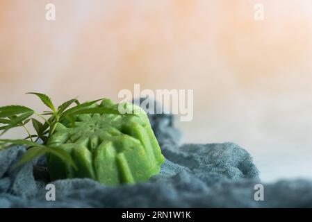 Grüne Seife auf Marihuana-Basis mit einem frischen Marihuana-Blatt auf hellem Hintergrund Stockfoto