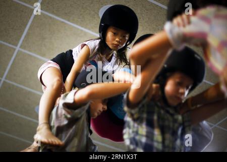 (150123) -- BARCELONA, 23. Januar 2015 -- Jana (1. L) nimmt am 26. September 2014 an einer Schulung zum Bau eines menschlichen Turms in Barcelona, Spanien, Teil. Jana ist ein 8-jähriges Kind aus China. Im Alter von anderthalb Jahren wurde sie von einem spanischen Paar, Andreu und Thais adoptiert und zog nach Barcelona. Vor einem Jahr beschloss Jana, dem lokalen Team von Castellers de Sants beizutreten. Derzeit ist Jana der Star des Teams. Sie ist diejenige, die die Spitze des menschlichen Turms besteigt. SPANIEN-BARCELONA-CASTELLERS PauxBarrena PUBLICATIONxNOTxINxCHN Barcelona Jan 23 2015 Jana 1st l nimmt an Stockfoto