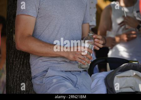 Mann, der eine Plastikflasche mit einem alkoholfreien Getränk hält. Stockfoto