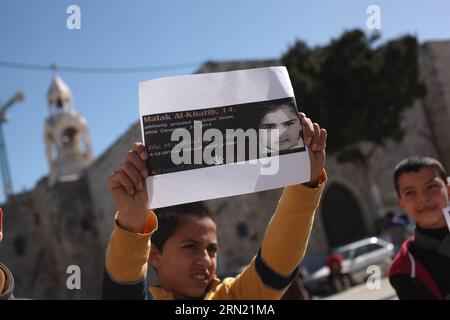 (150131) -- BETHLEHEM, 31. Januar 2015 -- Ein palästinensischer Junge hält ein Poster des 14-jährigen Malak al-Khatib während eines Protestes gegen die Verhaftung von al-Khatib und fordert ihre Freilassung vor der Geburtskirche in der Westjordstadt Bethlehem am 31. Januar 2015. Malak al-Khatib wurde am 31. Dezember 2014 verhaftet und ist laut palästinensischen Beamten das jüngste Mädchen, das jemals von Israel inhaftiert und verurteilt wurde. (lmz) MIDEAST-BETHLEHEM-PROTEST LuayxSababa PUBLICATIONxNOTxINxCHN Bethlehem Jan 31 2015 ein PALÄSTINENSISCHER Junge hält ein Poster des 14-jährigen Malak Al Khatib während einer Protestaktion Stockfoto