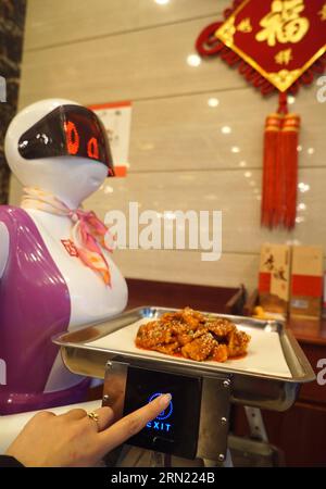 (150202) -- NANCHANG, 2. Februar 2015 -- Menschen drücken einen Knopf eines Roboterwarters, um seinen Wanderweg in einem Restaurant in Nanchang, Hauptstadt der ostchinesischen Provinz Jiangxi, 2. Februar 2015 zu ändern. Roboter-Kellner, die vor kurzem in Nanchang eingeführt wurden, haben mehr Gäste in das Restaurant gezogen. Jeder der Roboter-Kellner kann nach dem vollständigen Aufladen zehn Stunden lang ununterbrochen arbeiten. )(wjq) CHINA-JIANGXI-NANCHANG-ROBOTER-KELLNER (CN) ChenxZixia PUBLICATIONxNOTxINxCHN Nanchang 2. Februar 2015 Prominente Drücken Sie einen Knopf eines Roboter-Kellners, um seinen Wanderweg in einem Restaurant in der Hauptstadt von Nanchang zu ändern Stockfoto