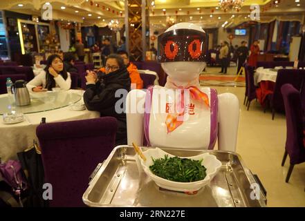 (150202) -- NANCHANG, 2. Februar 2015 -- Menschen beobachten einen Roboter-Kellner, der in einem Restaurant in Nanchang, der Hauptstadt der ostchinesischen Provinz Jiangxi, serviert, 2. Februar 2015. Roboter-Kellner, die vor kurzem in Nanchang eingeführt wurden, haben mehr Gäste in das Restaurant gezogen. Jeder der Roboter-Kellner kann nach dem vollständigen Aufladen zehn Stunden lang ununterbrochen arbeiten. )(wjq) CHINA-JIANGXI-NANCHANG-ROBOTER KELLNER (CN) ChenxZixia PUBLICATIONxNOTxINxCHN Nanchang 2 Februar 2015 Prominente Sehen Sie einen Roboter Kellner in einem Restaurant in Nanchang Hauptstadt von Ostchina S Jiangxi 2 Februar 2015 Roboter Kellner die Stockfoto