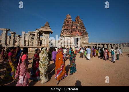 Touristen besuchen den Vittala-Tempel von Hampi im indischen Bundesstaat Karnataka Bellary, 7. Februar 2015. Hampi ist die letzte Hauptstadt des letzten großen Hindureiches Vijayanagar. Die fabelhaft reichen Fürsten errichteten dravidische Tempel und Paläste, die zwischen dem 14. Und 16. Jahrhundert die Bewunderung der Reisenden gewannen. Die Stadt, die 1565 von der muslimischen Konföderation der Dekkaner erobert wurde, wurde über einen Zeitraum von sechs Monaten geplündert, bevor sie aufgegeben wurde. Die Gruppen von Denkmälern in Hampi wurden 1986 zum UNESCO-Weltkulturerbe ernannt. Stockfoto