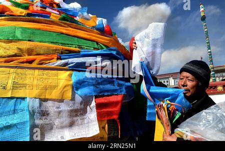 (150211) -- LHASA, 11. Februar 2015 -- Ein Devotee hängt Gebetsfahnen an einen Pfosten in der Nähe des Jokhang-Tempels in Lhasa, Hauptstadt der autonomen Region Tibet im Südwesten Chinas, 11. Februar 2015. Während das tibetische Neujahr naht, wurden Gebetsfahnen, die an den fünf Polen um den Jokhang-Tempel befestigt sind, durch neue ersetzt, die der tibetischen Tradition entsprechen. Das neue Jahr unter dem tibetischen Kalender fällt mit dem Frühlingsfest dieses Jahres zusammen, das am 19. Februar stattfindet. ) (hdt) CHINA-LHASA-JOKHANG TEMPEL-GEBET FAHNEN-ERSATZ (CN) Chogo PUBLICATIONxNOTxINxCHN Lhasa Feb 11 2015 ein Devotee hängt Gebet FLA Stockfoto