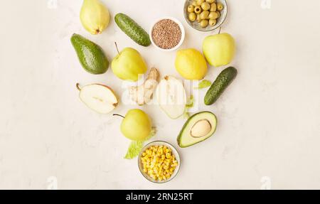 Herzform von gesunden FODMAP, Paleo, mediterrane Diät-Lebensmitteln in gelben und grünen Farben. Bio-Obst, Gemüse, Grünzeug, Leinsamen, Oliven. Stockfoto