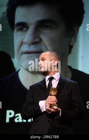 ROTER TEPPICH FÜR UNTERHALTUNG 65. Berlinale - Preisverleihung (150214) -- BERLIN, 14. Februar 2015 -- Darren Aronofsky, Präsident der Jury, hält den Goldenen Bären, während Irans Regisseur Jafar Panahi das Bild während der Preisverleihung beim 65. Berlinale International Film Festival in Berlin am 14. Februar 2015 auf dem Bildschirm sieht. ) DEUTSCHLAND-BERLIN-INTERNATIONALES FILMFESTIVAL-JAFAR PANAHI ZHANGXFAN PUBLICATIONXNOTXINXCHN Stockfoto