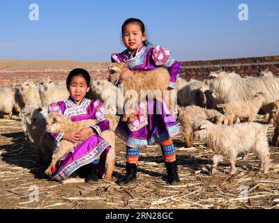 (150217) -- PEKING, 17. Februar 2015 -- Aktenfoto vom 19. März 2014 zeigt Kinder, die Lämmer auf einer Weide in der Gemeinde Wengeng von URAD Middle Banner in der Autonomen Region Innere Mongolei Nordchinas tragen. Die Chinesen feiern am 19. Februar dieses Jahres das Mondneujahr, das das Jahr der Ziege auf dem chinesischen Tierkreiszeichen markiert. ) (lfj) CHINA-YEAR OF GOAT (CN) ZhixMaosheng PUBLICATIONxNOTxINxCHN Peking 17. Februar 2015 Aktenfoto aufgenommen AM 19. März 2014 zeigt Kinder, die Lämmer AUF einer Weide in der Gemeinde URAD Middle Banner Nordchina S Innere Mongolei Autonome Region Chinesen feiern die Lu Stockfoto