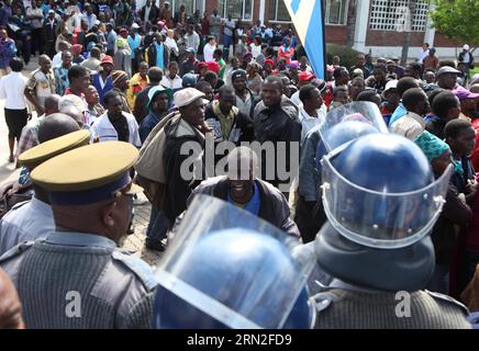 (150304) -- HARARE, 4. März 2015 () -- Riot Police Stand Guard as Tobacco Farmers Protest against low Auction prices before the Boka Tobacco Auction Floors in Harare, Simbabwe, 4. März 2015. Die Tabakverkaufssaison 2015 begann am Mittwoch mit Chaos, da die Landwirte bessere Preise für ihre Ernte verlangten. Simbabwe wird in diesem Jahr wahrscheinlich aufgrund ungünstiger Regenfälle einen Rückgang der Tabakproduktion in Virginia um 10 bis 15 Prozent verzeichnen, sagte ein hochrangiger Beamter. () SIMBABWE-HARARE-TOBACCO PRODUCTION-PROTEST Xinhua PUBLICATIONxNOTxINxCHN HARARE 4. März 2015 Riot Police Stand Guard to to Stockfoto