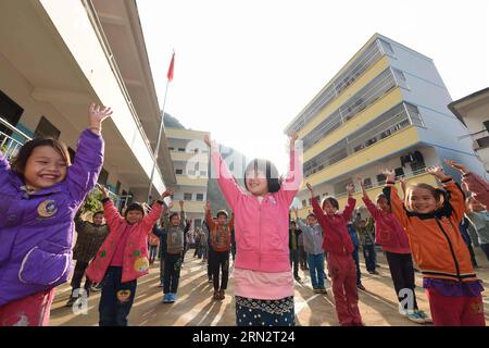 (150323) -- BANSHENG, 23. März 2015 -- Schüler machen Übungen auf ihrem neuen Spielplatz an der Nongyong Primary School im Bansheng County, südchinesische autonome Region Guangxi Zhuang, 24. November 2014. Die Nongyong Primary School wurde 1964 erbaut. Es liegt im Bansheng County, einem ländlichen Gebiet mit Karsttopographie in Guangxi. Das erste Schulgebäude besteht aus 12 einstöckigen Häusern. In den 1990er Jahren wurden ein zweigeschossiges Lehrgebäude und ein rauer Schlafsaal errichtet. Es gibt etwa 250 Studenten aus allen 22 Dörfern von Nongyong. Jeden Montag müssen die meisten von ihnen auf dem Weg zur Schule über Hügel laufen. In uns Stockfoto