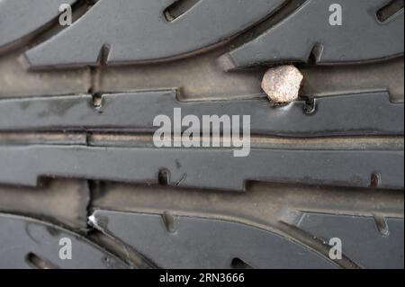 Stahlrostnagel im Autoreifen Makro Nahaufnahme. Flacher Reifen Stockfoto