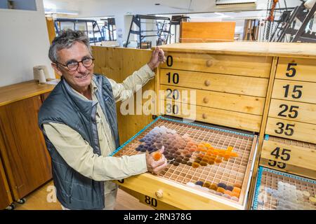 Frankreich, Herault, Lodève, Manufacture de la Savonnerie (Savonnerie Manufaktur) einzigartiger anbau der Nationalen Teppichfabrik der Savonnerie des Gobelins in Paris, Standortleiter Jean-Marc Sauvier devant le nuancier NIMES qui contient les pompons de laine échantillons Stockfoto