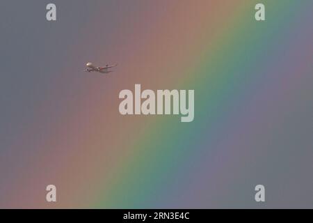 London, UK, 26. August 2023: Ein Flugzeug durchquert einen Regenbogen über Südlondon. Anna Watson/Alamy Stockfoto