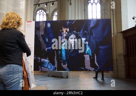 (150417) -- AMSTERDAM, 17. April 2015 -- Ein Besucher schaut sich Fotos der Weltpresse Photo 2015 an, die auf der Nieuwe Kerk in Amsterdam, Niederlande, am 17. April 2015 ausgestellt ist. Vom 18. April bis zum 5. Juli findet hier die Ausstellung World Press Photo 2015 statt. Jedes Jahr nach dem World Press Photo Contest gehen die Siegerbilder auf Tour um den Globus.) (Djj) NIEDERLANDE-AMSTERDAM-WELT PRESSEFOTOAUSSTELLUNG SylviaxLederer PUBLICATIONxNOTxINxCHN Amsterdam 17. April 2015 ein Besucher beobachtet Fotos ÜBER die Weltpresse Foto 2015 Aussteller AUF der Nieuwe Kerk in Amsterdam Niederlande 17. April 2015 Weltpresse Stockfoto