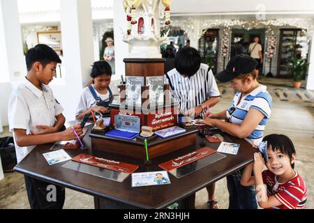 (150418) -- CHIANG RAI, 17. April 2015 -- Touristen schreiben auf Souvenirkarten im Wat Rong Khun in Chiang Rai, Thailand, 17. April 2015. Wat Rong Khun, allgemein bekannt als der Weiße Tempel, ist ein buddhistischer Tempel, der vom thailändischen Künstler Chalermchai Kositpipat entworfen wurde und im Besitz ist. Das Wat Rong Khun ist ein beliebtes Touristenziel in Chiang Rai und verfügt über weiße architektonische Strukturen, die mit silbrig reflektierenden Folien verziert sind, sowie dekorative zeitgenössische Gemälde. )(azp) THAILAND-CHIANG RAI-WAT RONG KHUN-WHITE TEMPLE LixMangmang PUBLICATIONxNOTxINxCHN Chiang Rai April 17 2015 Touristen Schreiben Sie AUF Souvenir Stockfoto