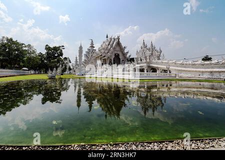 (150418) -- CHIANG RAI, 17. April 2015 -- Foto vom 17. April 2015 zeigt den Ubosot und die Brücke des Zyklus der Wiedergeburt , zwei Hauptstrukturen des Wat Rong Khun in Chiang Rai, Thailand. Wat Rong Khun, allgemein bekannt als der Weiße Tempel, ist ein buddhistischer Tempel, der vom thailändischen Künstler Chalermchai Kositpipat entworfen wurde und im Besitz ist. Das Wat Rong Khun ist ein beliebtes Touristenziel in Chiang Rai und verfügt über weiße architektonische Strukturen, die mit silbrig reflektierenden Folien verziert sind, sowie dekorative zeitgenössische Gemälde. )(azp) THAILAND-CHIANG RAI-WAT RONG KHUN-WHITE TEMPLE LixMangmang PUBLICATIONxNOTxIN Stockfoto