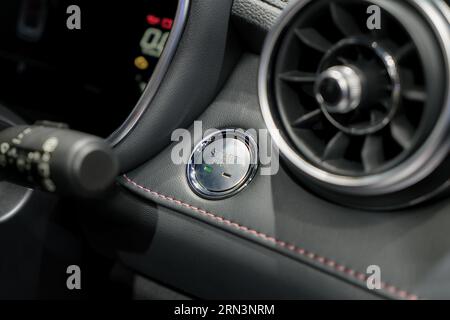 Die Motorstarttaste ist eine taktile Verbindung zur Stromversorgung und entzündet das Leben, während ihr Gegenstück die mechanische Herzfrequenz anmutig stoppt Stockfoto