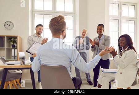Eine Gruppe glücklicher, vielfältiger Geschäftsleute, die den Erfolg ihrer Kollegen begrüßen Stockfoto