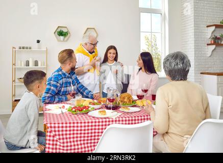 Happy Family hört zu, wie ein Großvater seiner Enkelin eine lustige Geschichte erzählt. Stockfoto