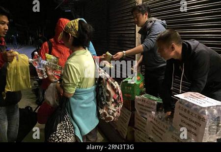 (150426) -- KATHMANDU, 26. April 2015 -- Mitglieder der nepalesischen Niederlassung des Beijing Charity Volunteer Association verteilen Wasser und Nahrung an Anwohner und eingeschlossene Touristen in Kathmandu, Nepal, 26. April 2015. Die Todesopfer des Erdbebens am Samstag überstiegen 1.800 und über 4.700 Menschen wurden verletzt, sagte das Home Minnistry of Nepal am Sonntag. (Foto mit Handy gemacht) NEPAL-KATHMANDU-ERDBEBEN-PEKING WOHLTÄTIGKEITSORGANISATION FREIWILLIGE lixxin PUBLICATIONxNOTxINxCHN Kathmandu April 26 2015 Mitglieder der nepalesischen Niederlassung der Beijing Charity Volunteer Association verteilen Wasser und Foo Stockfoto