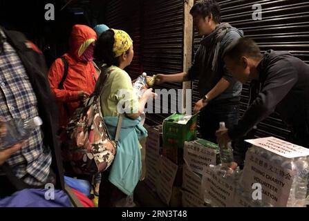 (150426) -- KATHMANDU, 26. April 2015 -- Mitglieder der nepalesischen Niederlassung des Beijing Charity Volunteer Association verteilen Wasser und Nahrung an Anwohner und eingeschlossene Touristen in Kathmandu, Nepal, 26. April 2015. Die Todesopfer des Erdbebens am Samstag überstiegen 1.800 und über 4.700 Menschen wurden verletzt, sagte das Home Minnistry of Nepal am Sonntag. (Foto mit Handy gemacht) NEPAL-KATHMANDU-ERDBEBEN-PEKING WOHLTÄTIGKEITSORGANISATION FREIWILLIGE lixxin PUBLICATIONxNOTxINxCHN Kathmandu April 26 2015 Mitglieder der nepalesischen Niederlassung der Beijing Charity Volunteer Association verteilen Wasser und Foo Stockfoto