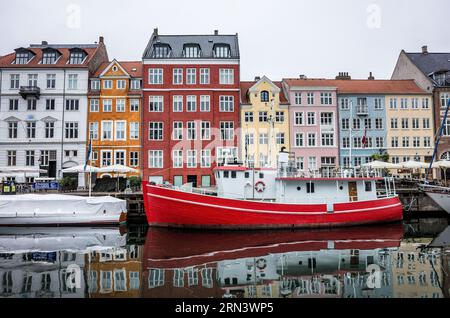 KOPENHAGEN, Dänemark – Nyhavn, der historische Hafen von Kopenhagen, ist voller Aktivitäten. Nyhavn war einst ein Handelshafen, in dem Schiffe aus der ganzen Welt anlegen sollten. Heute ist es ein kultureller Hotspot voller Restaurants, Bars und traditioneller Häuser, der seinen Wandel von einem geschäftigen maritimen Drehkreuz zu einer großen Touristenattraktion markiert. Stockfoto