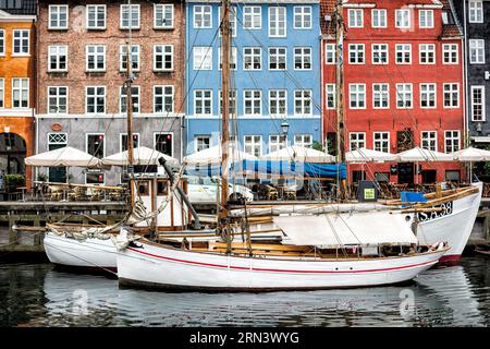 KOPENHAGEN, Dänemark – Nyhavn, der historische Hafen von Kopenhagen, ist voller Aktivitäten. Nyhavn war einst ein Handelshafen, in dem Schiffe aus der ganzen Welt anlegen sollten. Heute ist es ein kultureller Hotspot voller Restaurants, Bars und traditioneller Häuser, der seinen Wandel von einem geschäftigen maritimen Drehkreuz zu einer großen Touristenattraktion markiert. Stockfoto