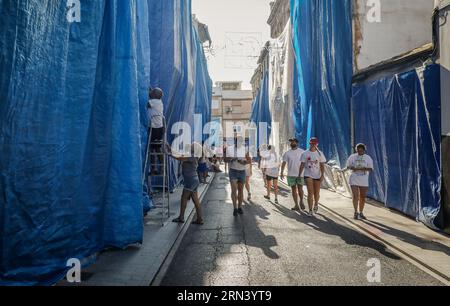 Valencia, Spanien. 30. August 2023. Ein paar Einheimische schützen die Fassade ihres Hauses vor Beginn der Tomatenschlacht. Ein weiteres Jahr, wie jeden letzten Mittwoch des Monats August, wurde La Tomatina in der valencianischen Stadt Buñol in Spanien gefeiert. Ein fest, das seit mehr als 50 Jahren stattfindet und an eine Meinungsverschiedenheit zwischen den Landwirten erinnert, die mit einem Tomatenkampf endete und das traditionelle Festival begründete. Quelle: SOPA Images Limited/Alamy Live News Stockfoto