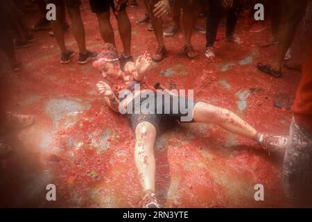 Valencia, Spanien. 30. August 2023. Eine Frau auf dem Boden schmiert sich während des tomatina-Festivals mit zerstoßener tomate. Ein weiteres Jahr, wie jeden letzten Mittwoch des Monats August, wurde La Tomatina in der valencianischen Stadt Buñol in Spanien gefeiert. Ein fest, das seit mehr als 50 Jahren stattfindet und an eine Meinungsverschiedenheit zwischen den Landwirten erinnert, die mit einem Tomatenkampf endete und das traditionelle Festival begründete. Quelle: SOPA Images Limited/Alamy Live News Stockfoto