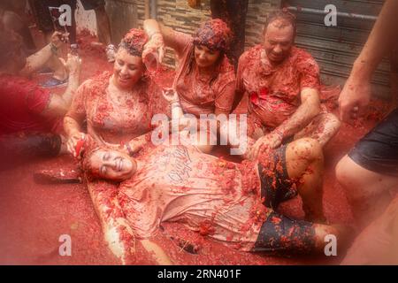 Valencia, Spanien. 30. August 2023. Eine Gruppe von Touristen füllt sich während des Tomatina Festivals mit zerstoßenen Tomaten. Ein weiteres Jahr, wie jeden letzten Mittwoch des Monats August, wurde La Tomatina in der valencianischen Stadt Buñol in Spanien gefeiert. Ein fest, das seit mehr als 50 Jahren stattfindet und an eine Meinungsverschiedenheit zwischen den Landwirten erinnert, die mit einem Tomatenkampf endete und das traditionelle Festival begründete. Quelle: SOPA Images Limited/Alamy Live News Stockfoto