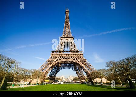 PARIS, Frankreich – Eine Weitwinkelaufnahme des Eiffelturms in Paris mit einem tiefblauen Himmel an einem Frühlingsmorgen. Diese Aufnahme stammt vom Champ de Mars. Der Eiffelturm wurde für die Weltausstellung 1889 gebaut und ist zu einem der bekanntesten Wahrzeichen der Welt geworden. Stockfoto