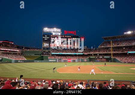 WASHINGTON D.C., USA – Bei Einem abendlichen Baseballspiel im Nationals Park treten die Washington Nationals gegen die Arizona Diamondbacks an. Das hell beleuchtete Feld steht im Kontrast zum dunklen Himmel und schafft eine lebendige Atmosphäre, während Spieler und Fans gleichermaßen an Amerikas Freizeit teilnehmen. Stockfoto