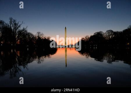 WASHINGTON DC, USA – das Washington Monument spiegelt sich bei Sonnenaufgang im ruhigen Wasser des Reflecting Pools. Das Licht am frühen Morgen taucht die National Mall in ein warmes Licht, das den berühmten Obelisken hervorhebt und eine ruhige und malerische Szene schafft. Das Washington Monument, eines der bekanntesten Wahrzeichen der Vereinigten Staaten, ist eine Hommage an den ersten Präsidenten der USA, George Washington. Stockfoto